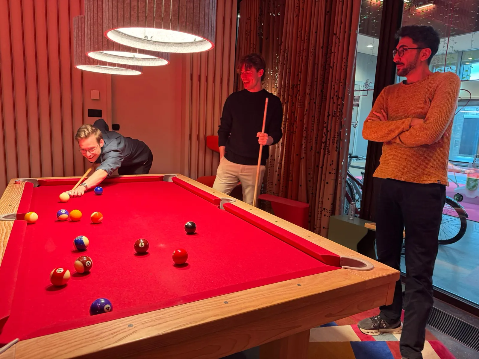 Three makers taking a break at a pool table